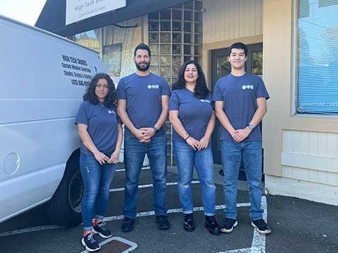 Dealership staff wearing the company shirt, standing next to the company vehicle