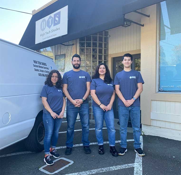 Dealership staff wearing the company shirt, standing next to the company vehicle